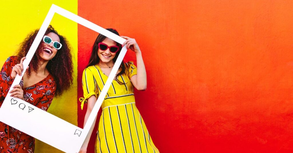 2 women holding a frame of an Instagram post