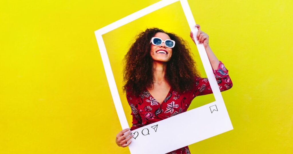 A woman holding a frame of an Instagram post