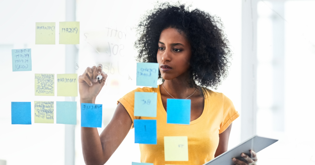 Woman planning tasks on a glass wall