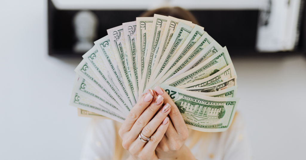 Hands holding a fan of US dollar bills