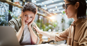 2 women with a laptopm looking disappointed.